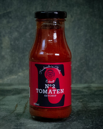 Glasflasche Eckart Ketchup No. 2 neben Bourbon-Whiskey-Flasche und Ahornsirup – Premium-Tomatenketchup mit edler Note.
