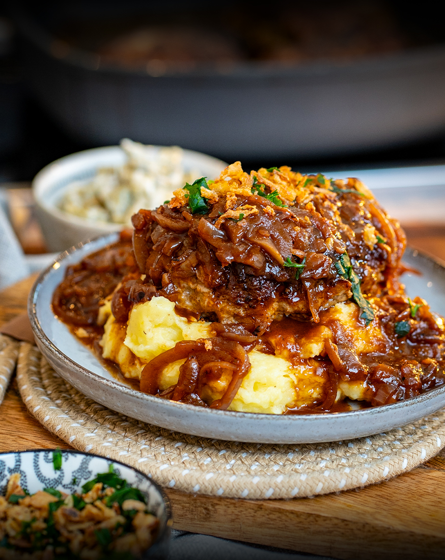 Dieses Gericht ist ein echtes Comfort-Food-Highlight: Zwiebelrostfrikadellen mit geschmorten Zwiebeln und einer richtig würzigen, braunen Soße.