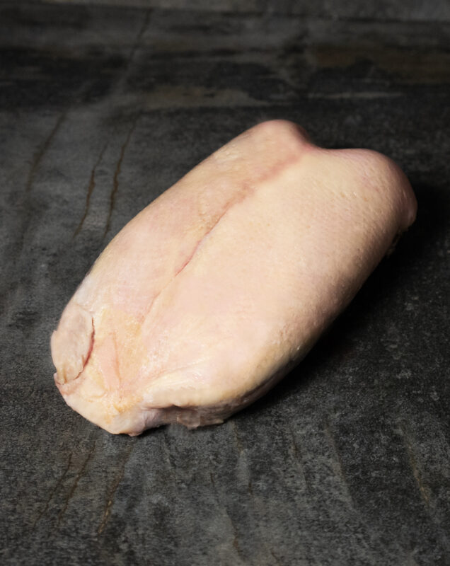 Gänsebrust aus Pommern roh auf Steinplatte, mit Knochen