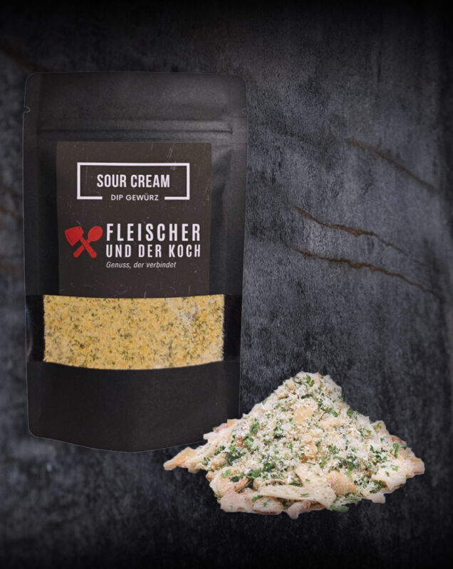 Schüssel mit Sour Cream Onion Dip, umgeben von Kräutern und Zwiebelstücken